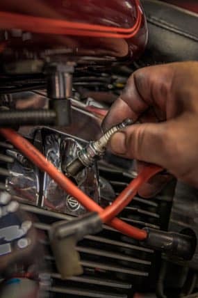A-Bikers-Garage-Service@2x Technician hand replacing spark plug