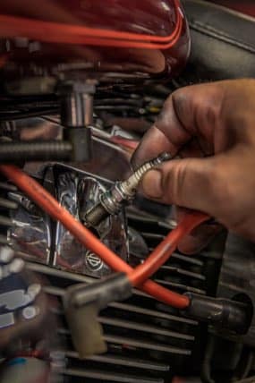 Technician hand replacing spark plug