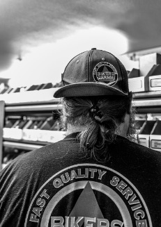 A Bikers Garage Worker with hat on backwards